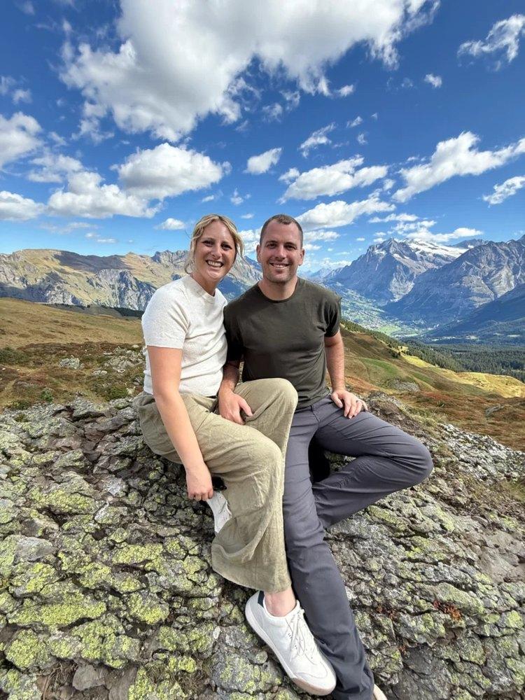 Ty and Jordyn sitting on a rocky overlook in the mountains